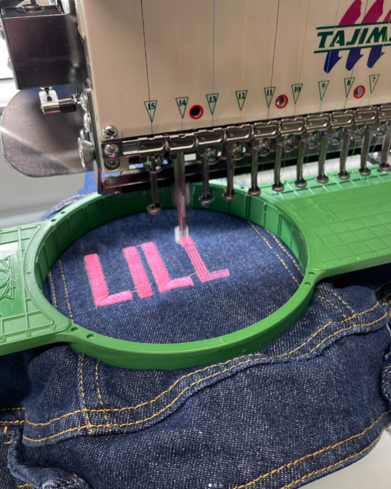 Tajima embroidery machine stitching pink lettering at X3 in Hull